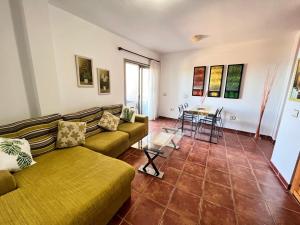 a living room with a couch and a table at Seafront Medano Marina View in El Médano