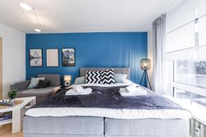 um quarto com uma cama grande e uma parede azul em DEHOME - Laguna - Stay by Central Station em Koblenz