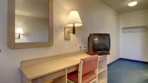 a room with a desk with a tv and a mirror at Motel 6-Owensboro, KY in Owensboro