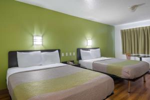 2 łóżka w pokoju z zielonymi ścianami w obiekcie Motel 6-Duncanville, TX - Dallas w mieście Duncanville