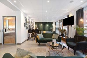 a living room with green couches and a tv at Best Western Plaza Hotel in Eskilstuna