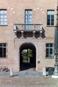an entrance to a brick building with a balcony at Palazzo Castiglioni Luxury Suites in Mantova