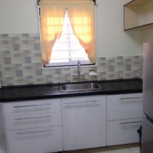 cocina con fregadero y ventana en Stunning 3-Bed House in Paramaribo Suriname, en Paramaribo