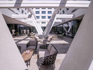 a patio with chairs and tables and a building at Mercure Debrecen in Debrecen