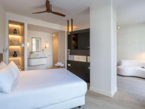 a bedroom with a white bed and a ceiling fan at Mercure Benidorm in Benidorm
