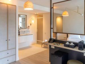 a bedroom with a bed and a desk and a mirror at Mercure Benidorm in Benidorm
