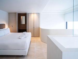 a bedroom with a white bed and a bathroom at Mercure Benidorm in Benidorm