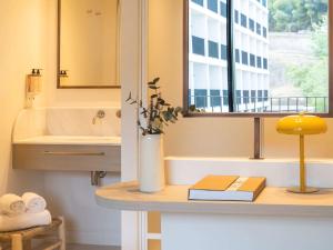 a bathroom with a sink and a mirror and a window at Mercure Benidorm in Benidorm