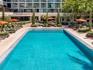 a swimming pool with chairs and a building at Mercure Benidorm in Benidorm