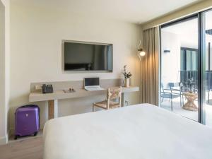 a hotel room with a bed and a desk with a laptop at Mercure Benidorm in Benidorm