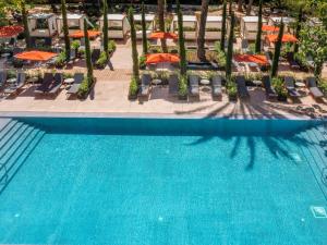 an overhead view of a swimming pool with chairs and umbrellas at Mercure Benidorm in Benidorm