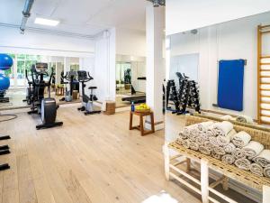 a gym with a bench and tread machines in a room at Mercure Benidorm in Benidorm