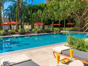 a swimming pool with chairs and a table with food on it at Mercure Benidorm in Benidorm
