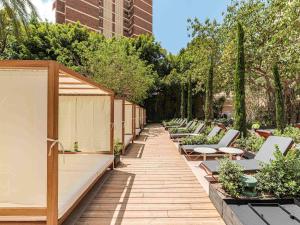a row of chairs and tables in a garden at Mercure Benidorm in Benidorm