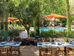 a patio with tables and chairs and a pool at Mercure Benidorm in Benidorm
