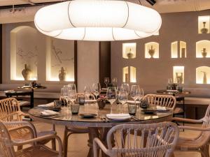 a dining room with a table and chairs and a chandelier at Mercure Benidorm in Benidorm