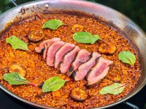 a pan of food with meat and mushrooms in it at Mercure Benidorm in Benidorm