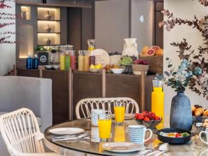 a table with chairs and a table with orange juice at Mercure Benidorm in Benidorm