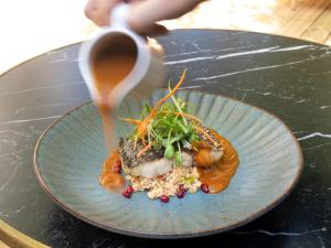 a plate of food on a table with a drink at Mercure Benidorm in Benidorm