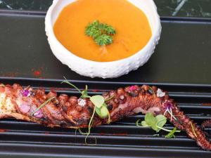a plate of food with meat and a bowl of soup at Mercure Benidorm in Benidorm