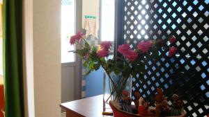 a vase with pink flowers sitting on a table at Plage Skhirat appartement amis et familles in Skhirat