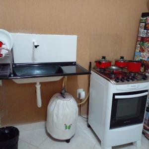 eine Küche mit Herd und Spüle sowie Töpfen und Pfannen in der Unterkunft Kitnet Itapuã in Vila Velha + 9 Fotos