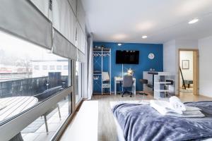een kamer met een bed, een bureau en een tv bij DEHOME - Laguna - Stay by Central Station in Koblenz