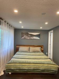 ein Schlafzimmer mit einem großen Bett mit Avertisation in der Unterkunft Modern main floor 3-bedroom apartment backing onto a park in Mississauga