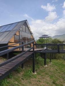 a house with a solarium and a picnic table and an umbrella at Wallaby Glamping in Silvania