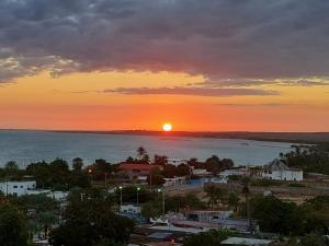 einen Sonnenuntergang über einer Stadt mit Meer und Stadt in der Unterkunft Yaque Suite in El Yaque