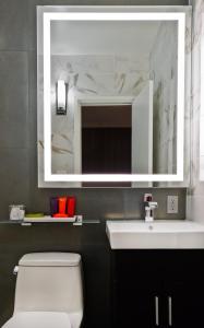 a bathroom with a sink, mirror, and toilet at Moderne Hotel in New York