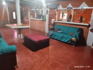 a living room with a blue couch and a table at Farm Lodge La Cabaña 