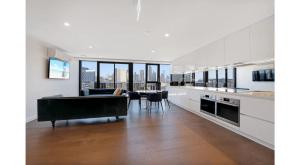 una cucina e un soggiorno con divano e tavolo di Two Bedroom Apartment in North Melbourne a Melbourne