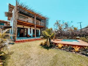 un patio trasero de una casa con piscina en Heruê Vila Praia do Espelho, en Porto Seguro