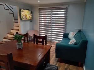 ein Wohnzimmer mit einem blauen Sofa und einem Tisch in der Unterkunft Cabañas y Departamentos Las Palmas, Temuco Depto 3 in Temuco