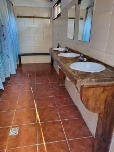 Baño con 2 lavabos y espejo en Hostel Randon, en La Pedrera