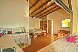 a kitchen and living room with a couch and a table at Pacifica Surf Studios in Santa Teresa Beach