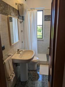 ein Bad mit einem Waschbecken, einem WC und einem Fenster in der Unterkunft Apartamento Davoli Marina in Marina di Davoli