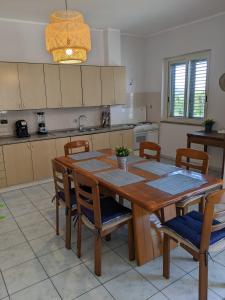 eine Küche mit einem Esstisch aus Holz und Stühlen in der Unterkunft Apartamento Davoli Marina in Marina di Davoli
