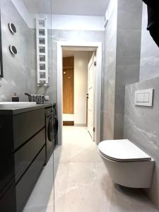 a bathroom with a toilet and a sink at Lovely Apartment in Krakow