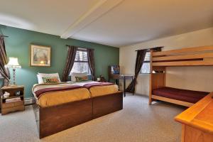 1 dormitorio con paredes verdes, 1 cama y escritorio en The Tanglewood Lodge- Amazing Ski Home for Groups, Hot Tub, Close to Killington Resort! home, en Killington