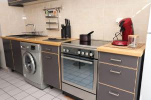 a kitchen with a stove and a washing machine at Votre confort la Cosy Cocoon in Courcouronnes +10 photos