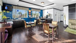 Un comedor con mesas y sillas y paredes azules. en Belmont Inn and Suites Tatum, en Tatum