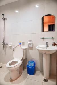 un baño con inodoro y lavabo en A&A ABE BAYFRONT INN, en Corón 37 fotos más