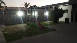 a playground with a slide in a yard at night at POUSADA CHALEIRA PRETA - Hospedagem & Conveniência in Arroio do Silva