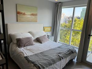 a bedroom with a bed with a large window at Apartamento nuevo en Congreso- amplio- vista inigualable in Buenos Aires