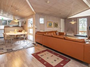 ein Wohnzimmer mit einem großen Sofa und einem Tisch in der Unterkunft 10 person holiday home in V ggerl se in Bøtø By