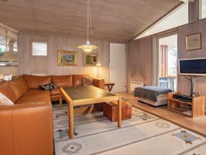 ein Wohnzimmer mit einem Sofa und einem Tisch in der Unterkunft 10 person holiday home in V ggerl se in Bøtø By