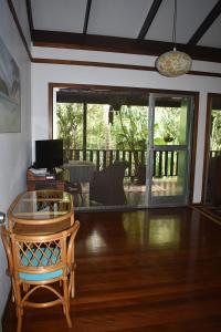 uma sala de estar com uma cadeira e uma mesa em Oskar's Rain Forest Retreat em Nelly Bay