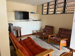 a living room with a couch and two chairs at TETE Comforts in Roseau